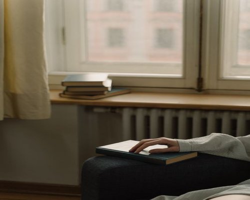 Modern Peruvian apartment with soft natural lighting and a person reading a book